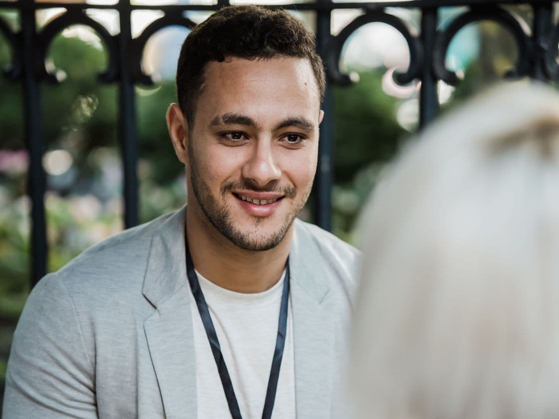A man in a grey blazer chatting over coffee at a networking event