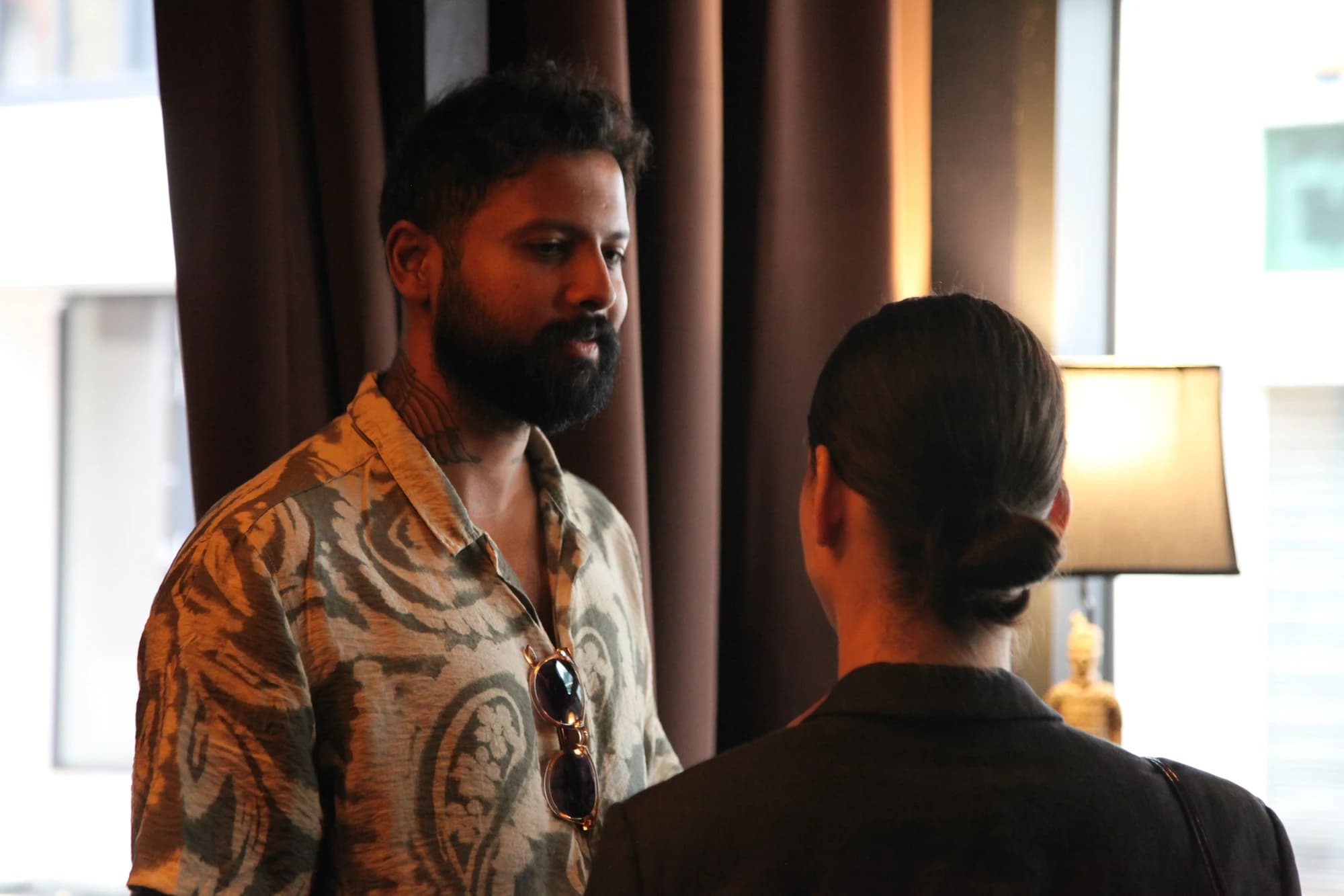 A man stands speaking to a woman with black hair at a Flynt in-person event